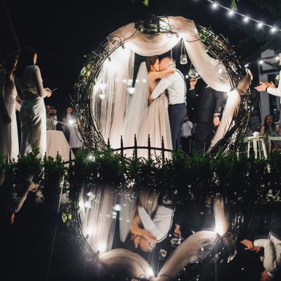 Look from behind wedding altar at cheerful wedding couple during the ceremony