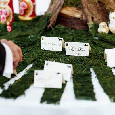 Man takes card with guest name from the table with decorative grass